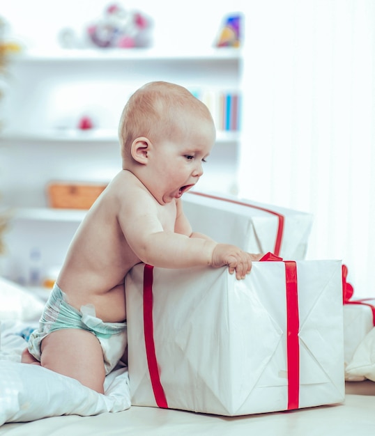 Lindo bebé de un año jugando con compras en cajas en el sof