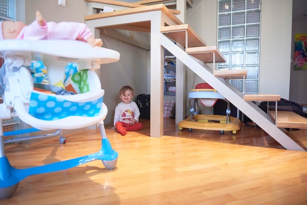 Un lindo bebé de un año jugando con juguetes en casa mientras da los primeros pasos y aprende a caminar