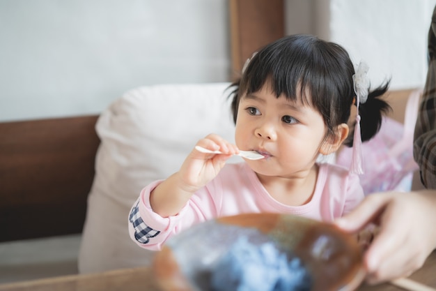 Lindo bebé y aquí madre comiendo helado en el café