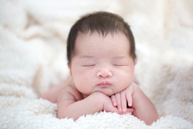 Foto lindo bebê asiático recém-nascido dormindo no cobertor peludo