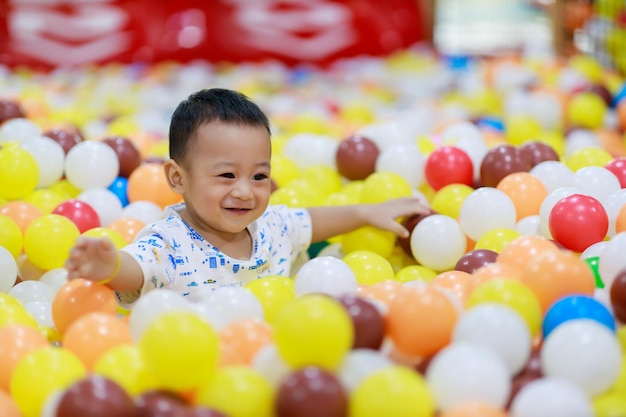 Lindo bebé asiático se ríe y juega con juguetes sintiéndose feliz y alegre en el patio interior Concepto de familia de bebés