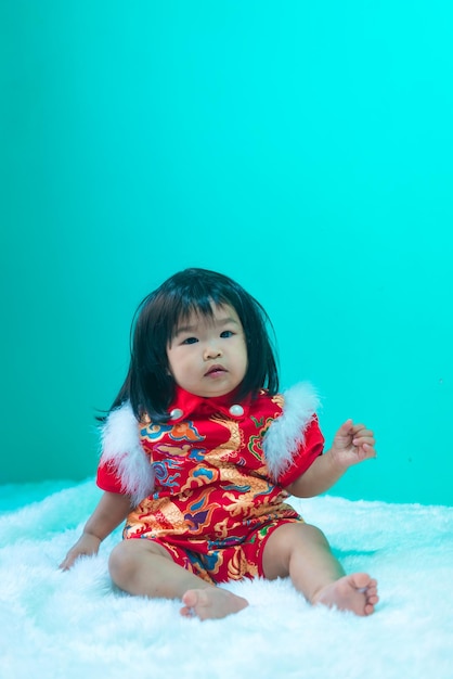 Lindo bebé asiático usar vestido cheongsamFeliz año nuevo chino conceptoTailandia niña