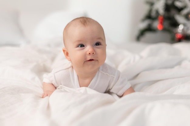 Lindo bebé en casa en la cama para Navidad El primer regalo de Navidad de Año Nuevo