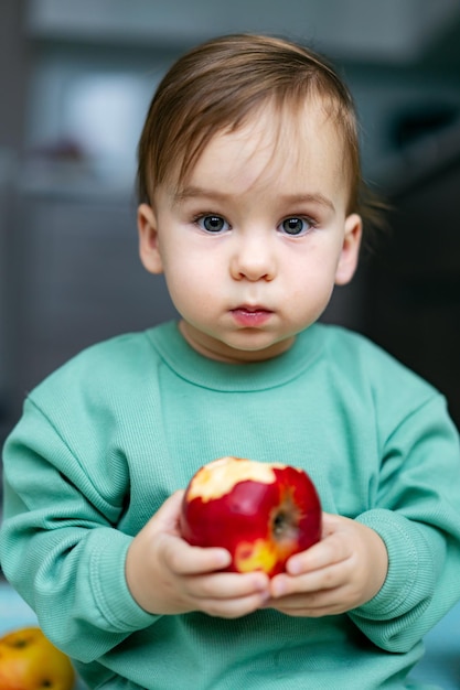Lindo bebé comiendo manzana en casa Nutrición infantil saludable