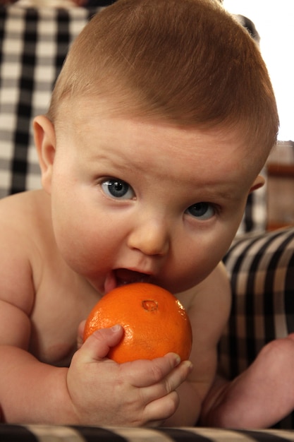 Lindo bebé comiendo una naranja