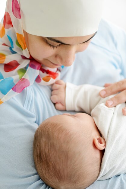 Lindo bebê de dois meses nas mãos de sua mãe muçulmana