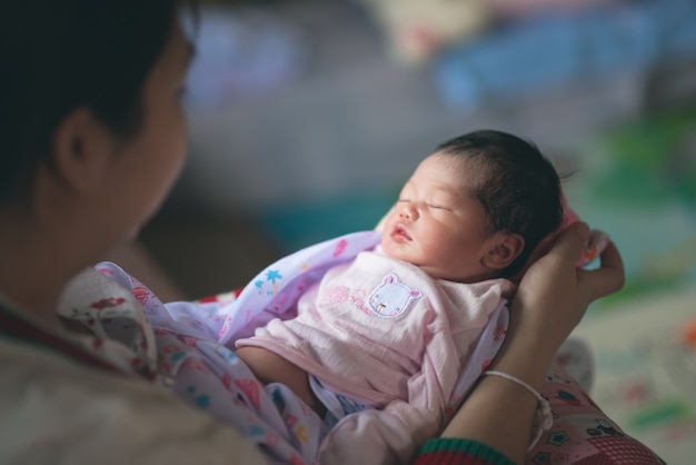 Lindo bebé duerme en la mamá de la mano