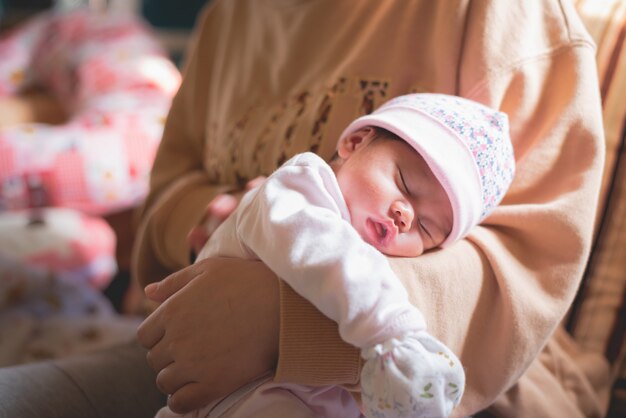 Lindo bebé duerme en la mamá de la mano