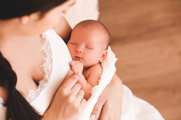 Lindo bebé durmiendo en primer plano de manos de la madre