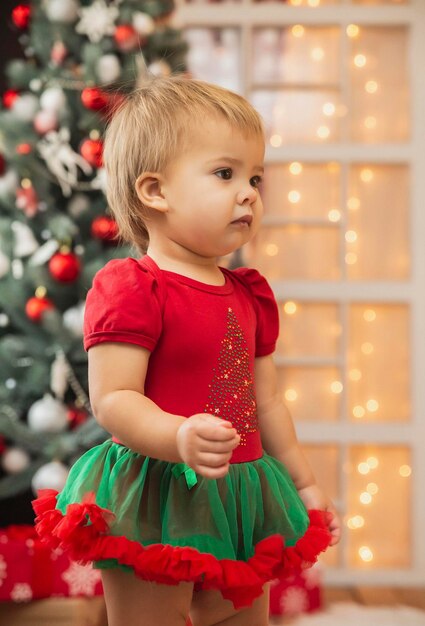 Lindo bebê em um terno de ano novo. Decorações de Natal.