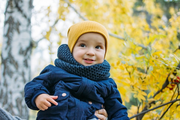 Lindo bebé feliz en ropa casual en otoño parque natural