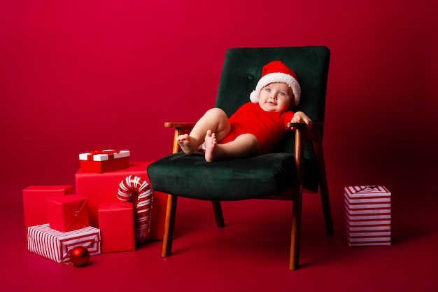 Lindo bebé con un gorro de Papá Noel en una silla
