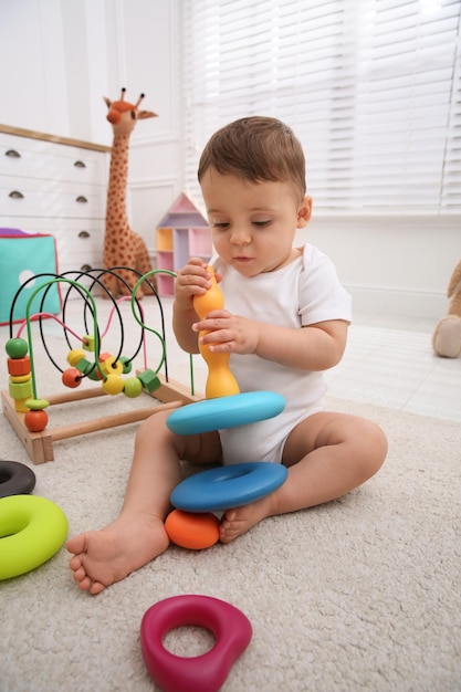 Foto lindo bebé jugando con juguetes en el suelo en casa