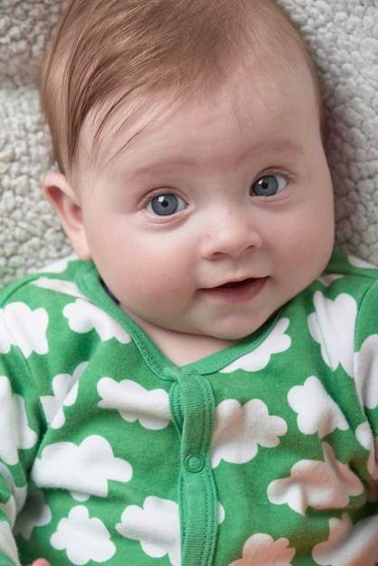 lindo bebé jugando con la mano y sonriendo sin dientes sonrisa graciosa