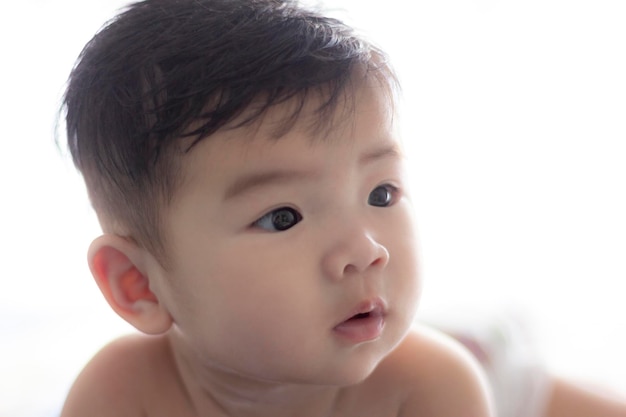Lindo bebé mirando hacia el lado sorprendido Adorable retrato de bebé mirando curioso aislado en blanco