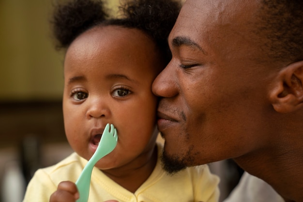 Foto lindo bebé negro en casa con sus padres