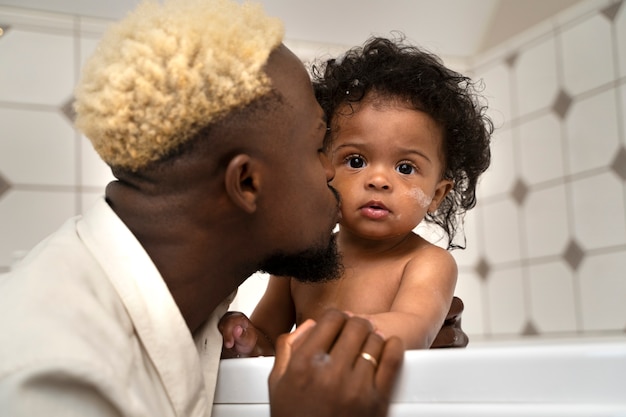 Foto lindo bebê preto em casa com os pais