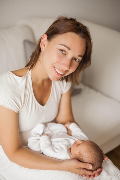 Lindo bebê recém-nascido dormindo nos braços da mãe. maternidade.