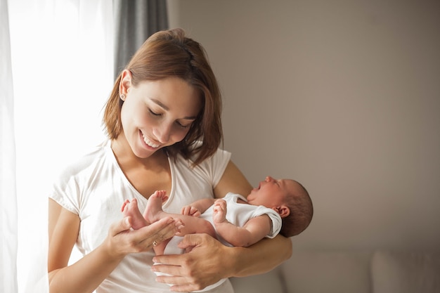 Lindo bebê recém-nascido dormindo nos braços da mãe. Maternidade.