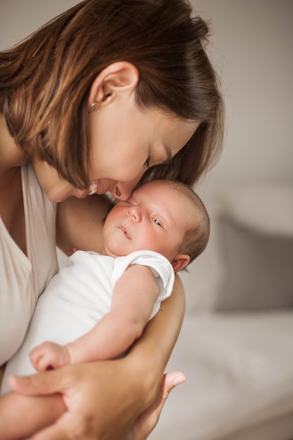 Lindo bebê recém-nascido dormindo nos braços da mãe. Maternidade.