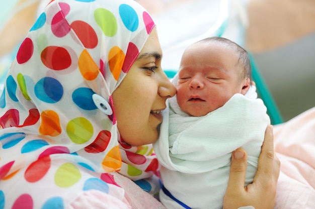 Lindo bebê recém-nascido nas mãos de suas mães.