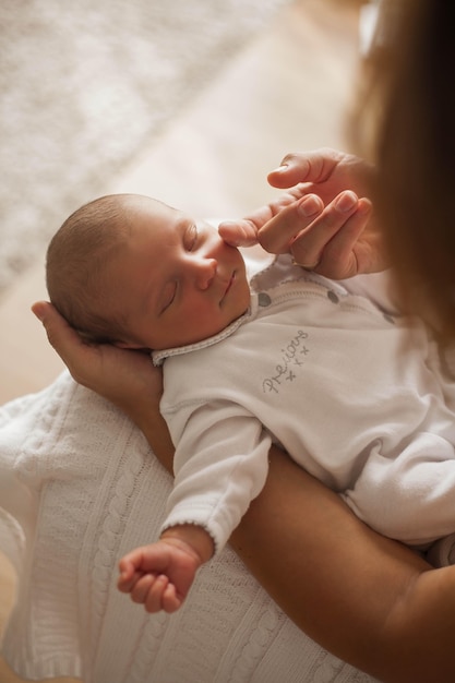 Lindo bebé recién nacido durmiendo en brazos de la madre. Maternidad.