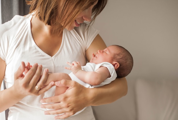 Lindo bebé recién nacido durmiendo en brazos de la madre. Maternidad.