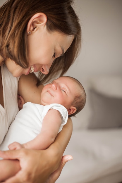 Lindo bebé recién nacido durmiendo en brazos de la madre. Maternidad.