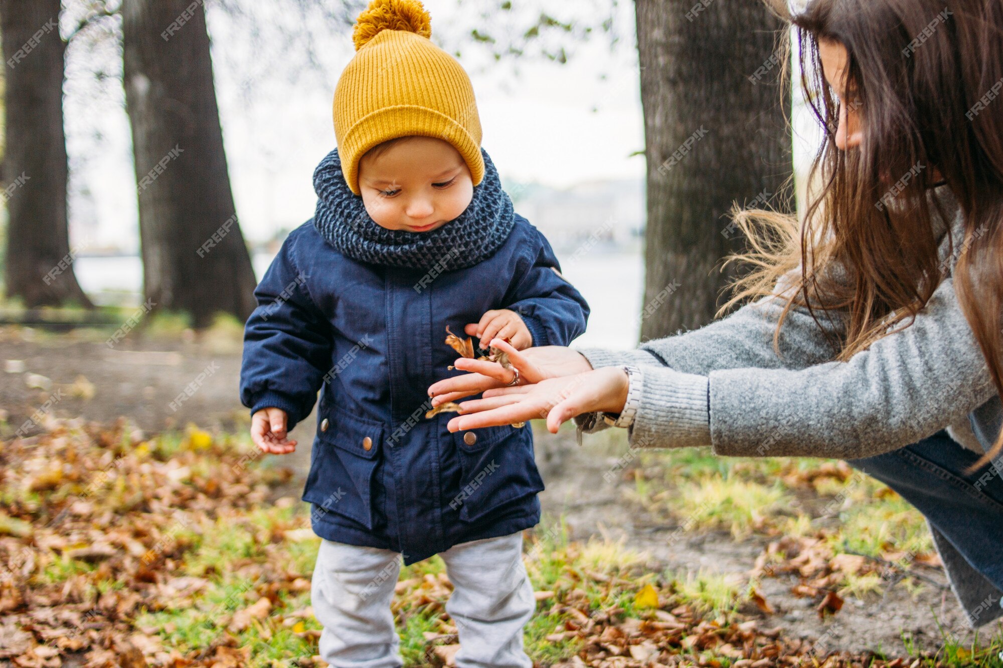 Lindo bebé en ropa casual de moda explora el mundo con la madre en el parque natural de otoño | Premium