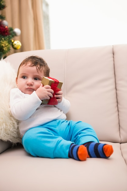 Lindo bebé en el sofá en Navidad