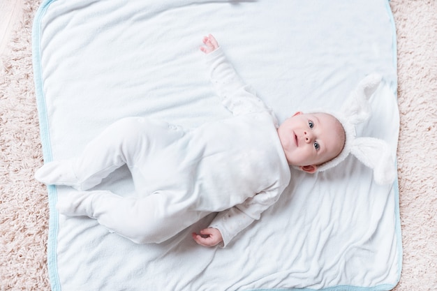 Lindo bebé sonriente acostado en la cama