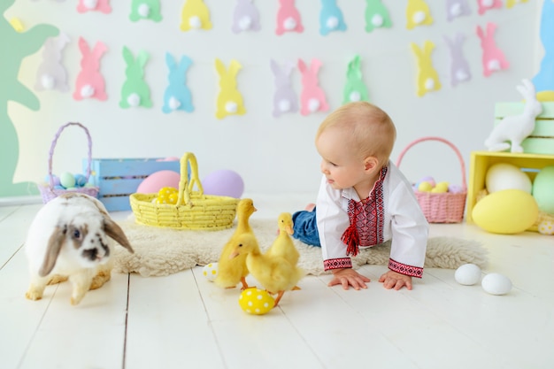 Foto lindo bebé sonriente en bordado tradicional en decoraciones de pascua de colores