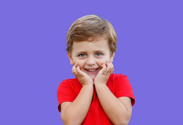 Lindo bebé sorprendido con ojos azules aislado en un fondo púrpura