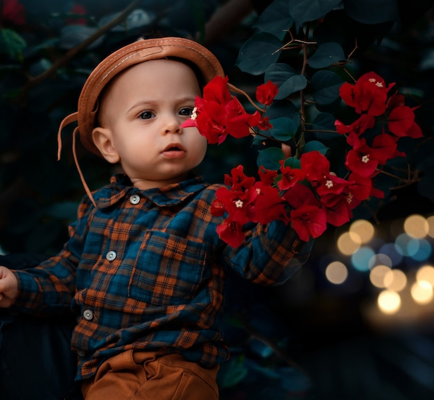 Lindo bebé vaquero con flores rojas