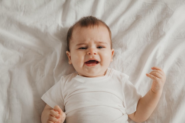 Lindo bebé yace en la cama retrato de vista superior de un niño en la cama