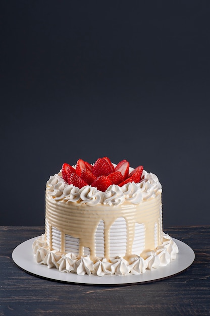 Lindo bolo de aniversário coberto com chantillly e morango fresco. Plano de fundo cinza. Copie o espaço