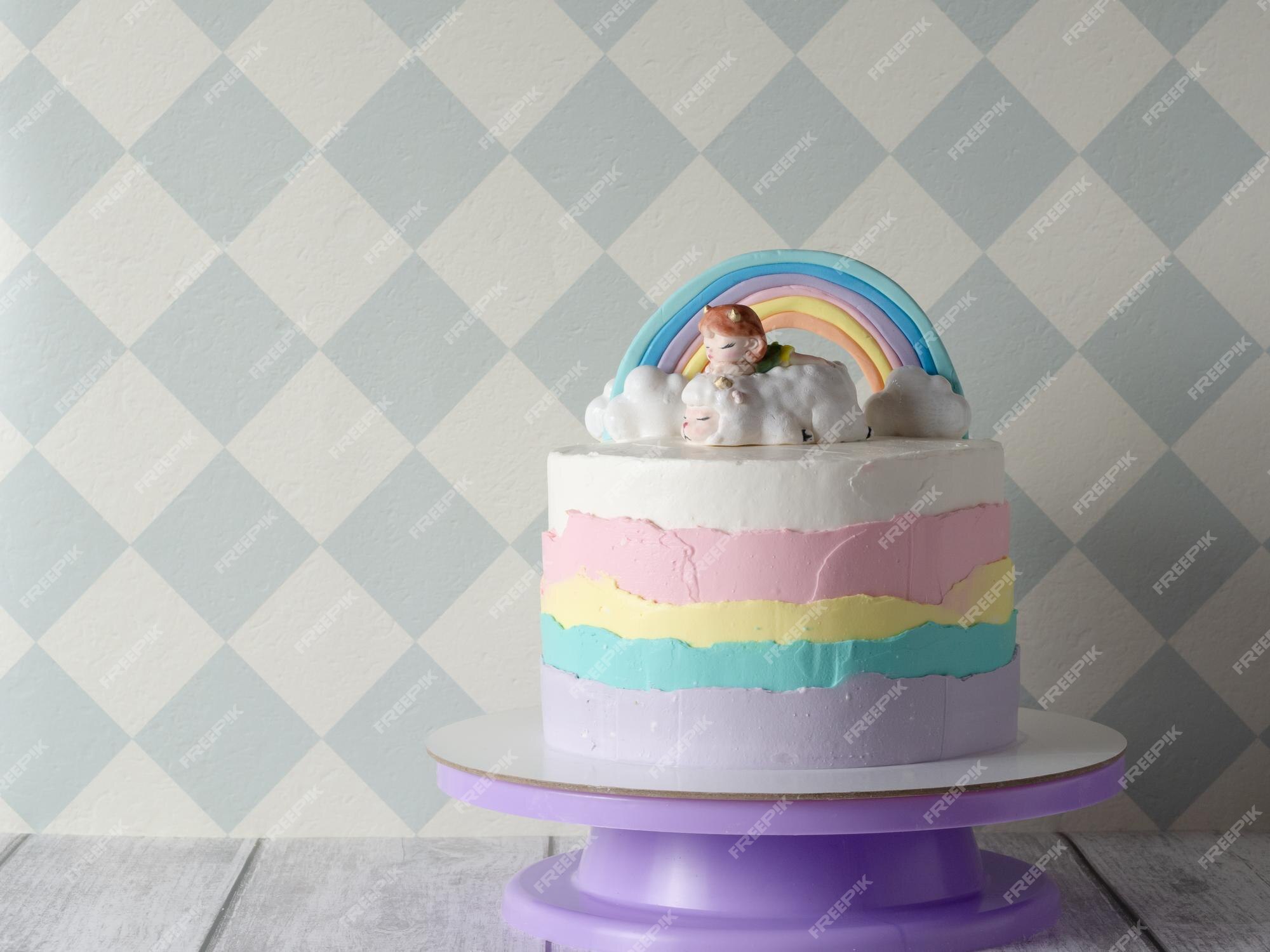 Lindo bolo de aniversário infantil colorido para um bolo de menina com  nuvens de arco-íris e uma estatueta de uma menina o conceito de férias  infantis