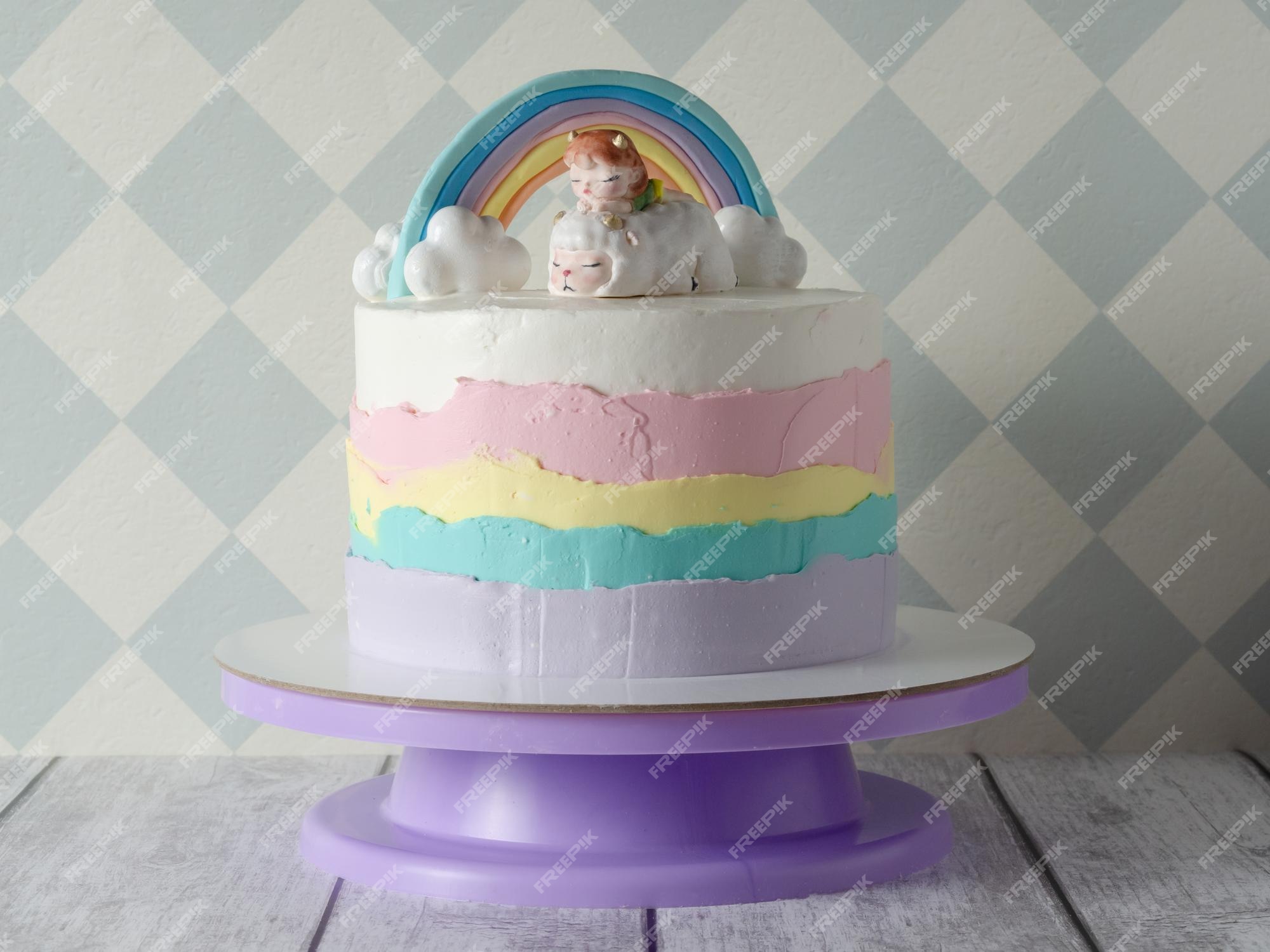 Lindo bolo de aniversário infantil colorido para um bolo de menina com  nuvens de arco-íris e uma estatueta de uma menina o conceito de férias  infantis