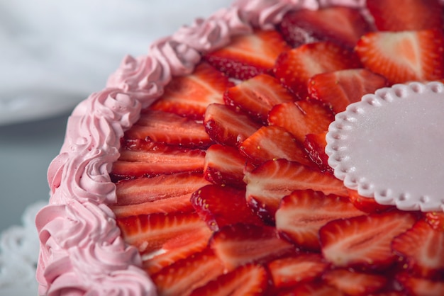 Foto lindo bolo de creme por cima decorado com morangos fatiados e lugar para texto