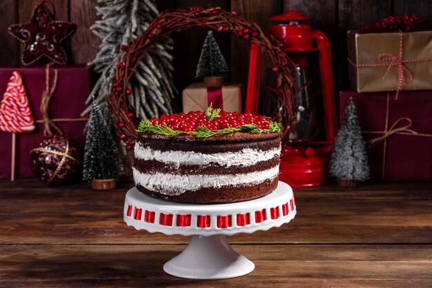 Lindo bolo delicioso com bagas vermelhas brilhantes na mesa de natal