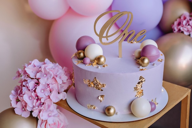 Lindo bolo rosa para o aniversário de uma menina em um fundo de bolas cor de rosa