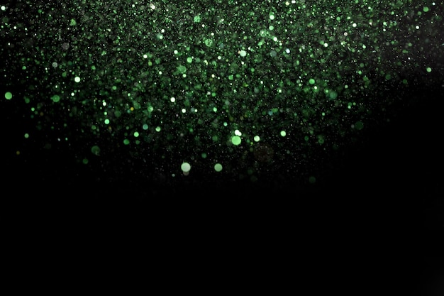 Foto lindo brilho verde brilhante caindo de cima em um fundo escuro