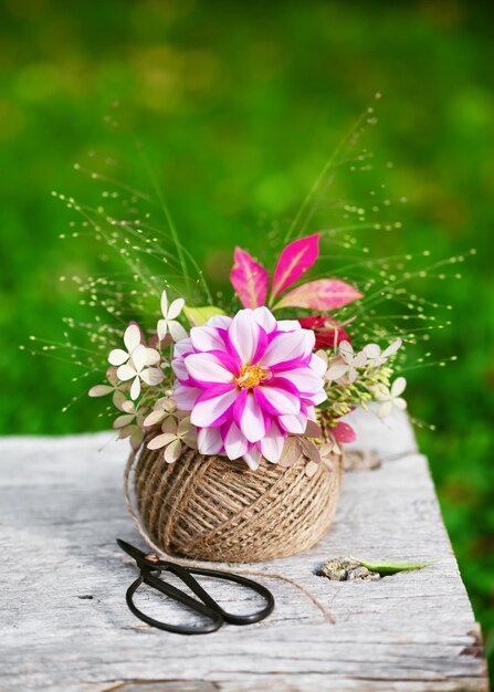 Lindo buquê com flores de hortênsia dália branca rosa, grama e folhas de outono em um barbante