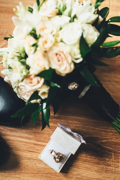 Lindo buquê de casamento com anéis no fundo de madeira