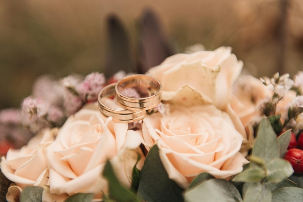 Lindo buquê de casamento com protea e alianças de rosas em um fundo de floresta