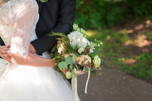 Lindo buquê de casamento na mão dos noivos