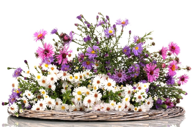 Lindo buquê de flores brilhantes no tapete de vime isolado no branco