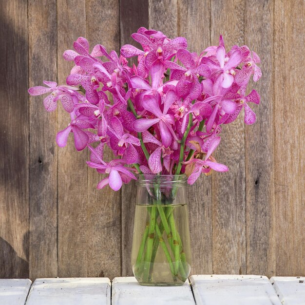 Lindo buquê de flores de orquídeas em um fundo de madeira