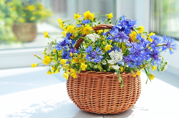 Lindo buquê de flores e camomilas em uma cesta