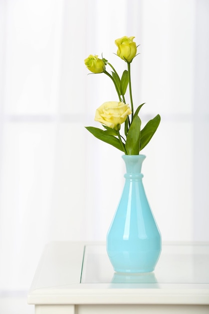 Lindo buquê de flores em vaso no fundo da janela